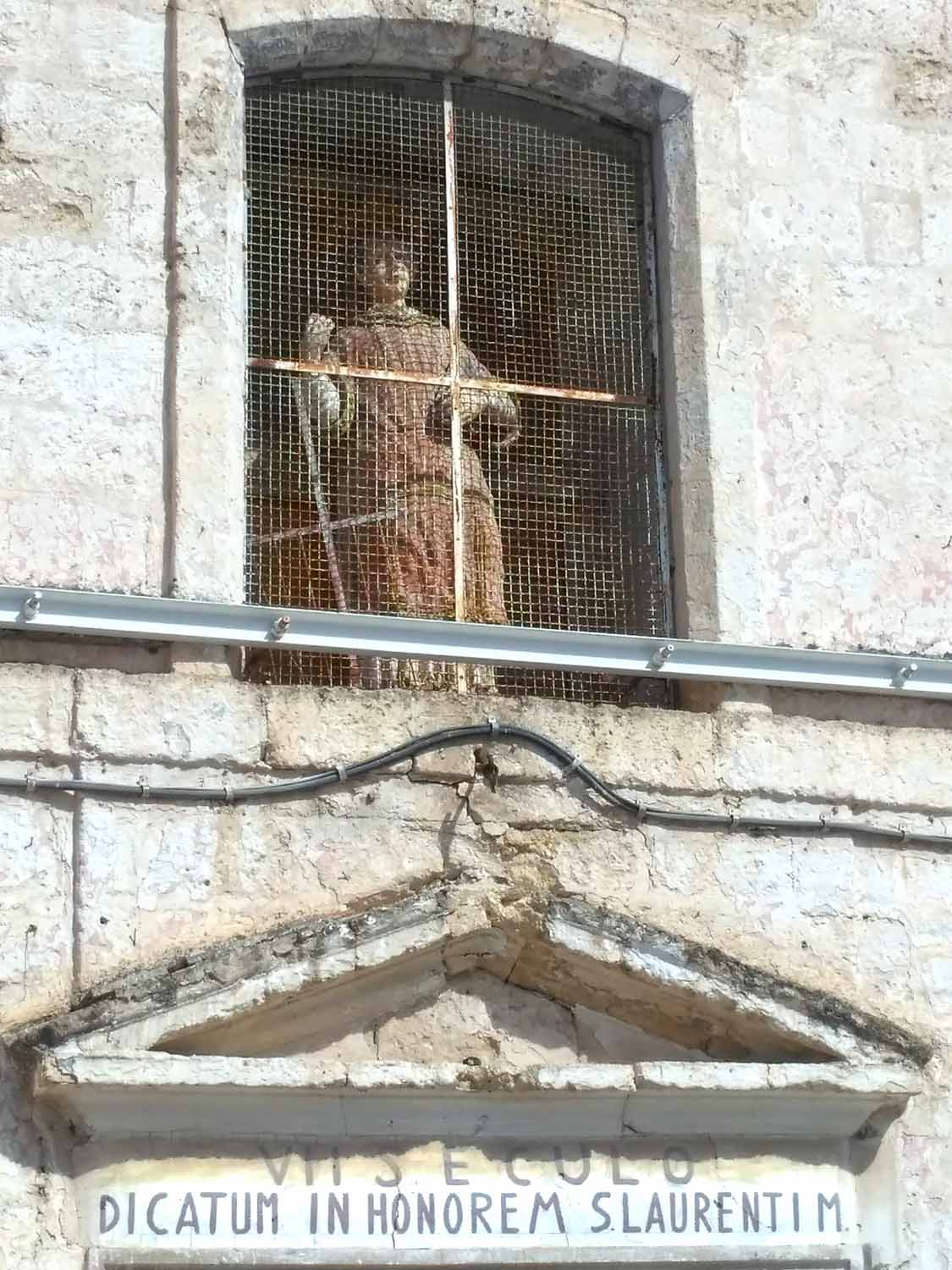 la statua fittile di San Lorenzo nella finestra dell'omonima chiesa