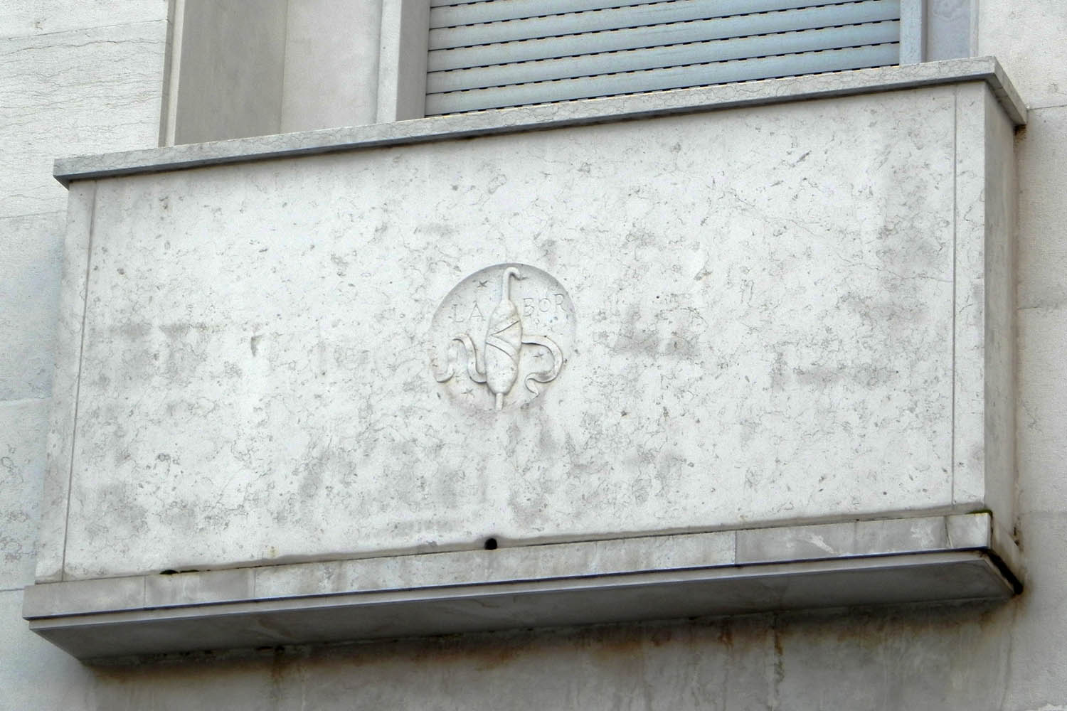 Il balcone ad angolo con lo stemma dell'opificio