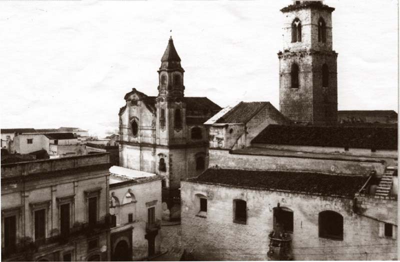 Veduta della Chiesa della Trinità, affiancata al monastero delle Benedettine (non visibile) - sulla destra la Cattedrale, in una foto precedente la demolizione (1934)